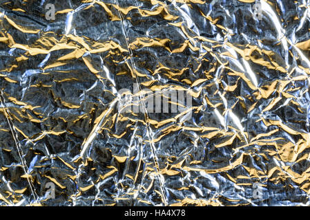 Crumpled Aluminum tin foil texture with light reflections on the shiny metallic silver wrapping Stock Photo