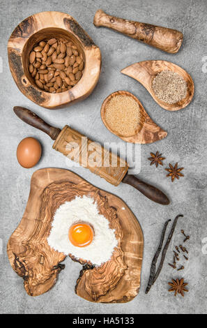 Food background. Baking utensils and ingredients on kitchen table. Eggs, flour, sugar, almond, vanilla Stock Photo