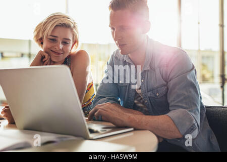 Two young students using laptop in class. university students working on laptop computer in library. Stock Photo