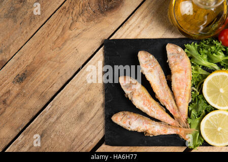 Fried red mullet fish served on a plate slate Stock Photo