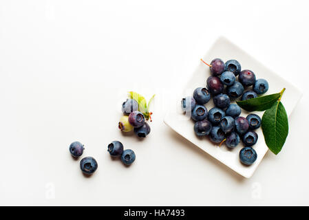 Fresh blueberries with green leaves on white background Stock Photo