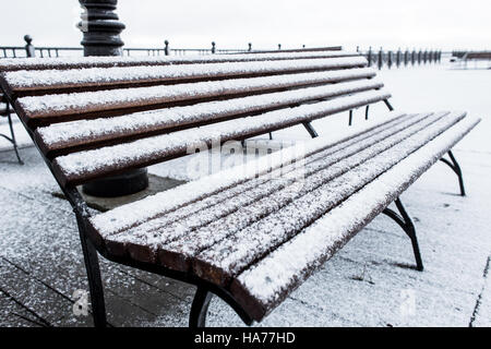 Frozen bench covered gritty rough hoarfrost on a cloudly winter day Stock Photo