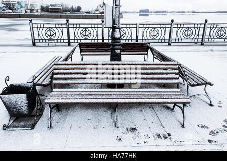 Frozen bench covered gritty rough hoarfrost on a cloudly winter day Stock Photo