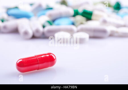 Red capsule closeup on a white surface Stock Photo