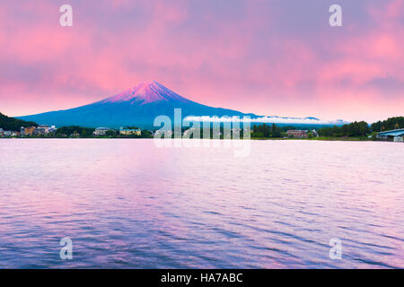 Fiery colorful sky above the red crater cone of Mount Fuji at dawn sunrise over Lake Kawaguchiko water on summer morning, Japan Stock Photo