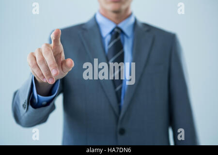 Mid section of businessman touching an invisible screen Stock Photo