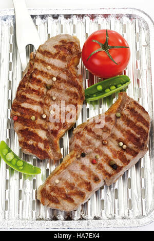 Rump steak with grill marks in an aluminium tray Stock Photo