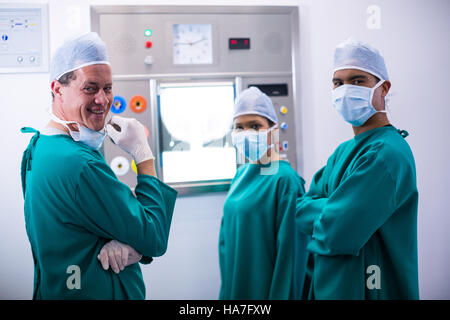 Surgeons discussing a report on surgical monitor in operation room Stock Photo
