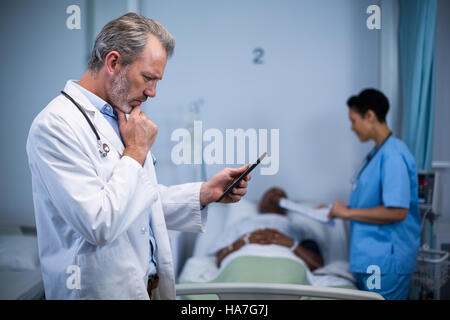 Doctor using digital tablet in ward Stock Photo