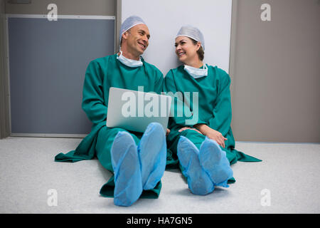 Surgeons using laptop in corridor Stock Photo