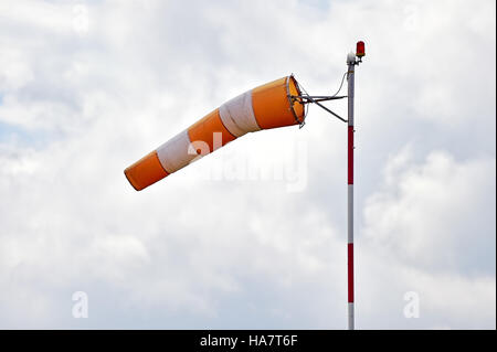 Windsock blown by the wind with overcast sky on background Stock Photo