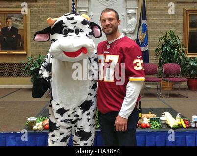 This image shows a USDA official, Doughty, working with a dairy cow. The USDA supports dairy farming through research, policy development, and promoting best practices to ensure sustainable agriculture and animal welfare. Stock Photo