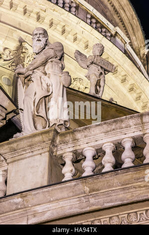 In the foreground statue in stone and in the background a stone ángel with the words 'venite' Stock Photo