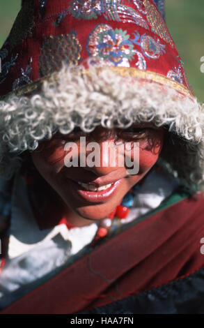 An ethnic Khampa woman wearing a traditional summer hat- a sheep lined sun hat covered in silk brocade Stock Photo