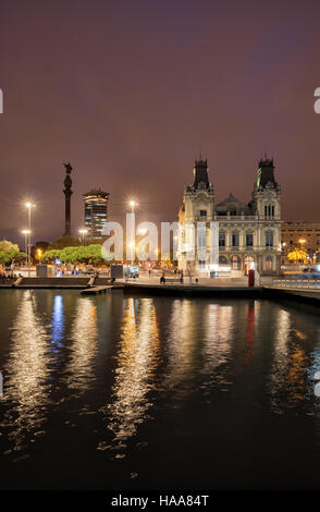 City of Barcelona by night in Catalonia, Spain, view from Port Vell, in skyline Columbus Monument and Old Customs building Stock Photo