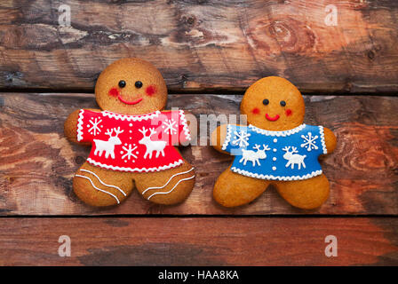 Smiling Christmas gingerbread men on wooden background. Stock Photo