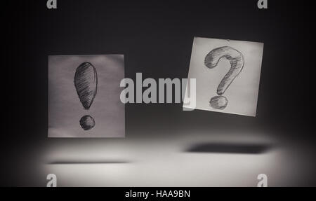 Exclamation and question signs drawn on paper, on gray background. Stock Photo