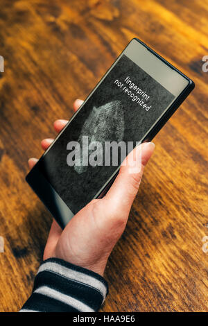 Fingerprint not recognized message on mobile smartphone screen after a sensor scan of female thumb failed to authenticate user and unlock electronics Stock Photo