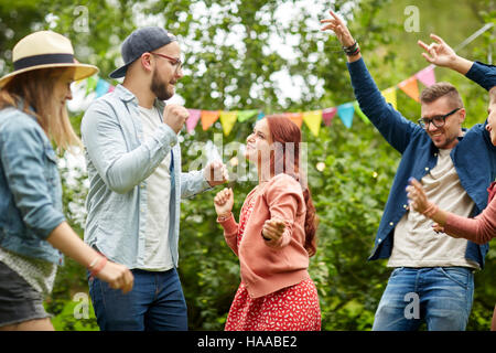 happy friends dancing at summer party in garden Stock Photo