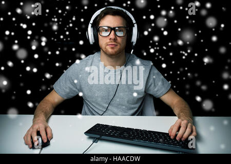 man in headset playing computer video game Stock Photo