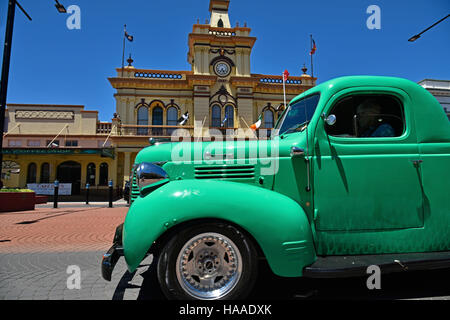 classic green fargo truck passes in front of the historic Glen Innes town hall in the main atreet, grey street, of glen innes Stock Photo