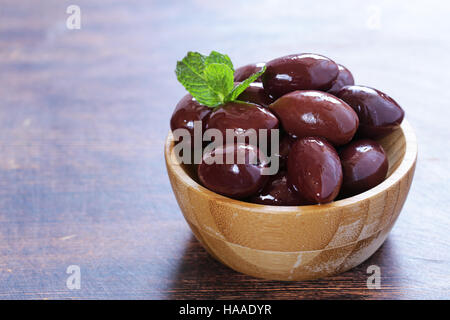 red kalamata olives on a wooden table Stock Photo