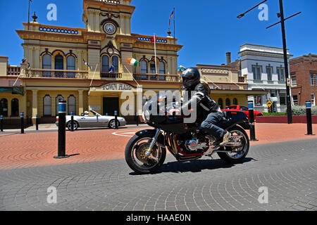 harris kawasaki passes in front of the historic Glen Innes town hall in the main atreet, grey street, of glen innes Stock Photo