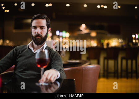 Man looking at glass of red wine Stock Photo
