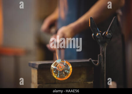 Glassblower shaping a molten glass Stock Photo