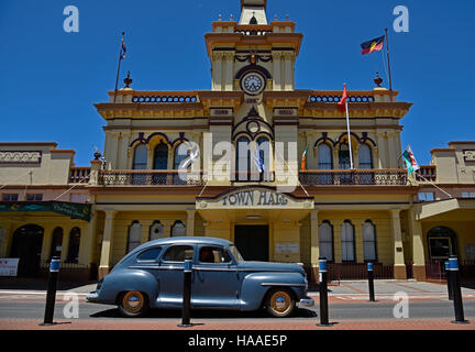 classic plymouth car passes in front of the historic Glen Innes town hall in the main atreet, grey street, of glen innes Stock Photo