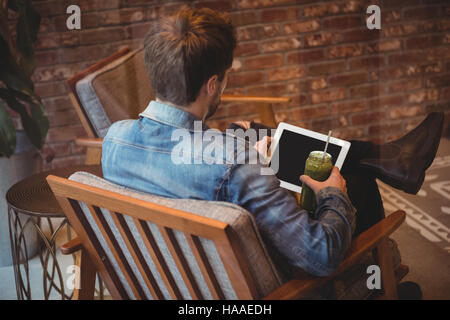 Man using digital tablet while having juice Stock Photo
