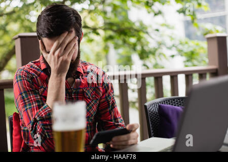 Upset man holding mobile phone Stock Photo