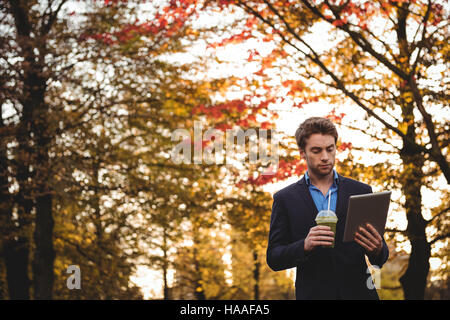Businessman using digital tablet while having juice Stock Photo