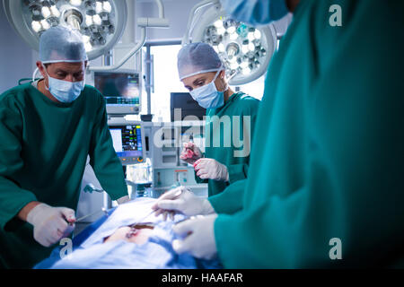 Surgeons performing operation in operation theater Stock Photo