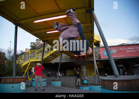Parkour practitioners underneath the yellow gantry on the Southbank, London, United Kingdom. The South Bank is a significant arts and entertainment district, and home to an endless list of activities for Londoners, visitors and tourists alike. Stock Photo