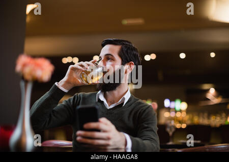 Man holding mobile phone and having a drink Stock Photo