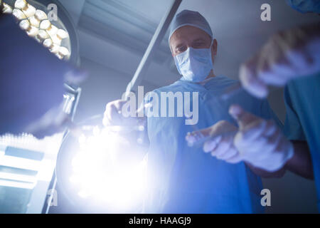 Surgeons performing operation in operation room Stock Photo