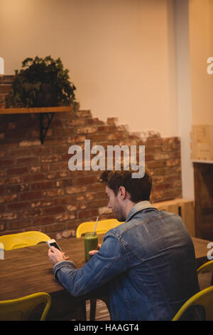 Man using mobile phone while having juice Stock Photo