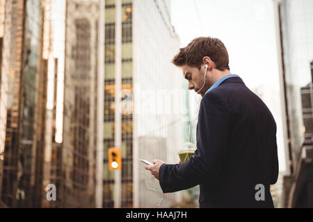 Businessman listening to music and using mobile phone Stock Photo