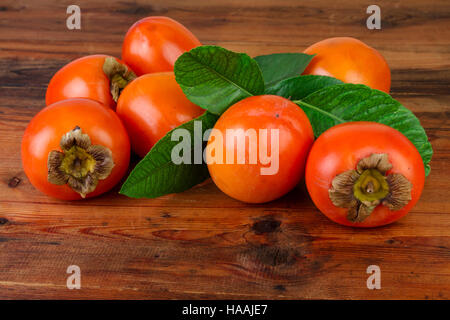 persimmon kaki fruits on wooden table Stock Photo