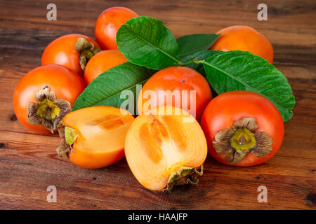 ripe persimmons kaki fruits on rustic background Stock Photo