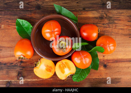 Persimmons kaki fruits on rustic table. Top view. Stock Photo