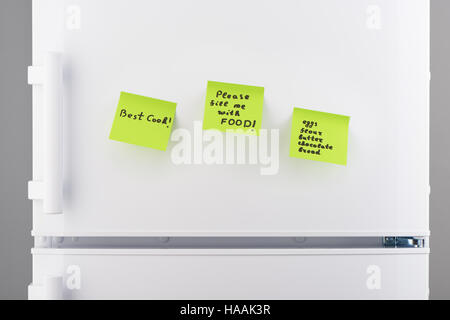 Best cook, please feel me with food notes and shopping list on green sticky note paper on white refrigerator door Stock Photo