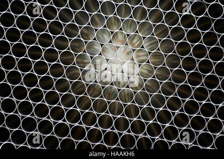 Industrial background. Close up of internal metal pipes in a warehouse. Stack of new and shiny steel pipe in factory. Stock Photo