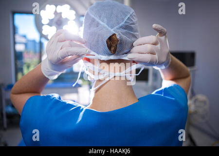 Rear view of female nurse wearing surgical cap in operation theater Stock Photo