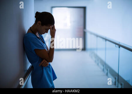 Sad nurse standing in corridor Stock Photo