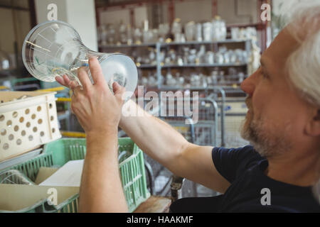Glassblower examining glassware Stock Photo