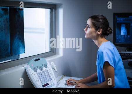 Nurse taking notes in x-ray room Stock Photo