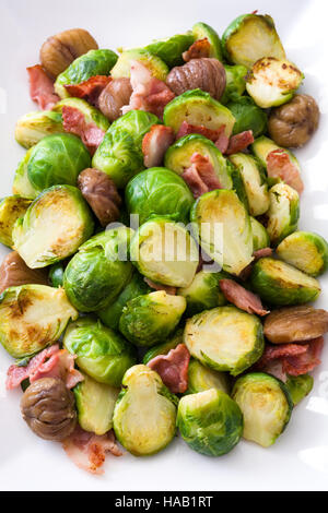 Brussels sprouts with chestnuts and bacon isolated on white background Stock Photo