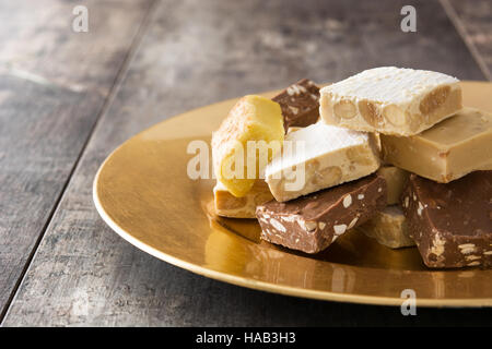 Christmas nougat on a golden plate on wooden background.Copyspace Stock Photo
